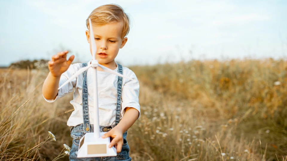 Boy playing with toy wind turbine outdoors