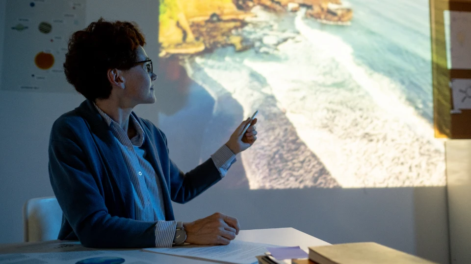Teacher pointing at coastline in classroom