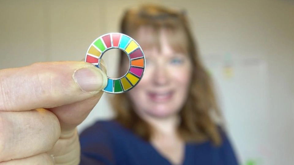 The woman holding small colorful circle