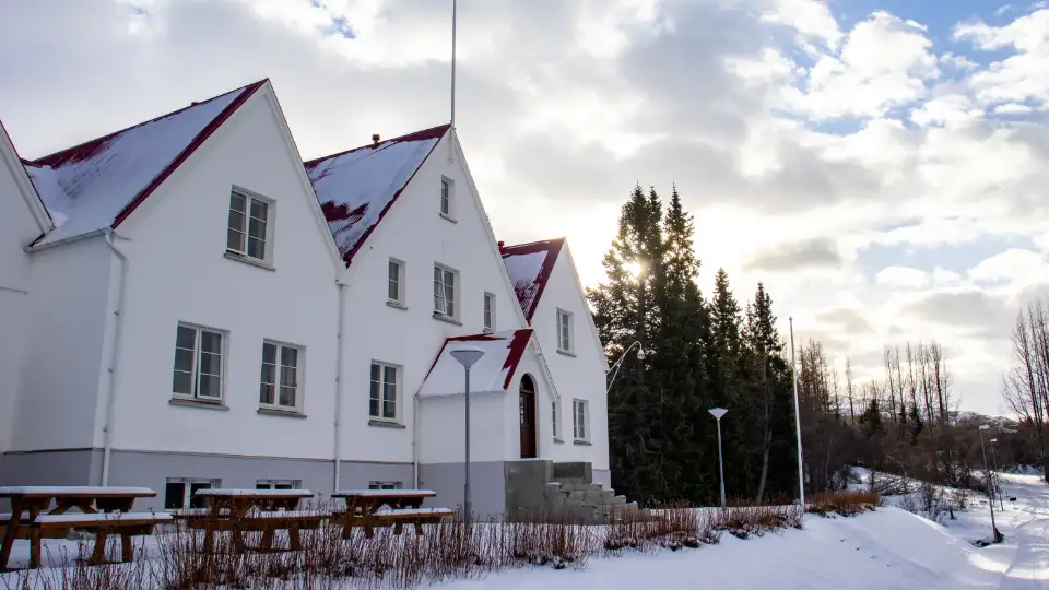 Skolebygningen i Hallormsstað er midt inne i en skog og arkitekten er Guðjón Samúelsson, en av Islands best kjente arkitekter.