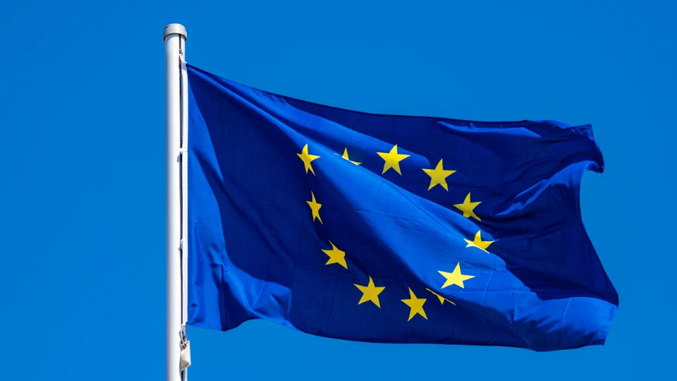 Styrkede bevilgninger til europeisk utdanningssamarbeid og mobilitetsprosjekter EU-flagget vaier i vinden mot en klar blå himmel.