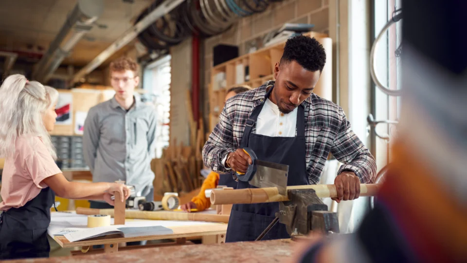 ECTS i høyere yrkesfaglig utdanning kan styrke livslang læring En mannlig student bruker en sag til å kutte et rør i et verksted, mens medstudenter observerer og samarbeider rundt et arbeidsbord.