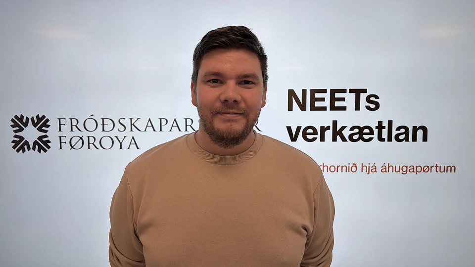 Hallur Mohr Sverrason Hallur Mohr Sverrason, der står foran en hvid baggrund med tekst og logoer. Han har mørkt hår, kort skæg og er iført en beige sweatshirt. Bag ham ses logoet for Fróðskaparsetur Føroya og teksten "NEETs verkætlan"