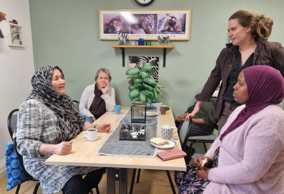 Fyra personer runt ett fikabord.