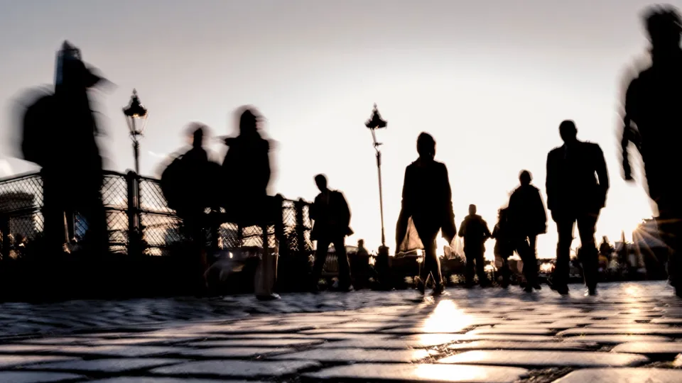 State of the Nordic Region 2026 Blurred silhouettes of people walking on a cobblestone bridge at sunset.
