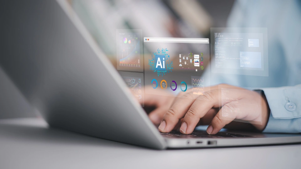 Person typing on a laptop with transparent AI dashboards and data visualizations overlaid on the screen.