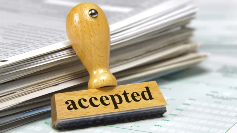 Trestempel med teksten «accepted» foran en bunke dokumenter.