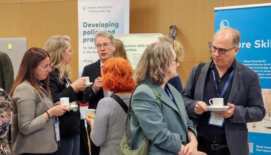 Conference attendees networking over coffee during a lifelong learning and skills research event.