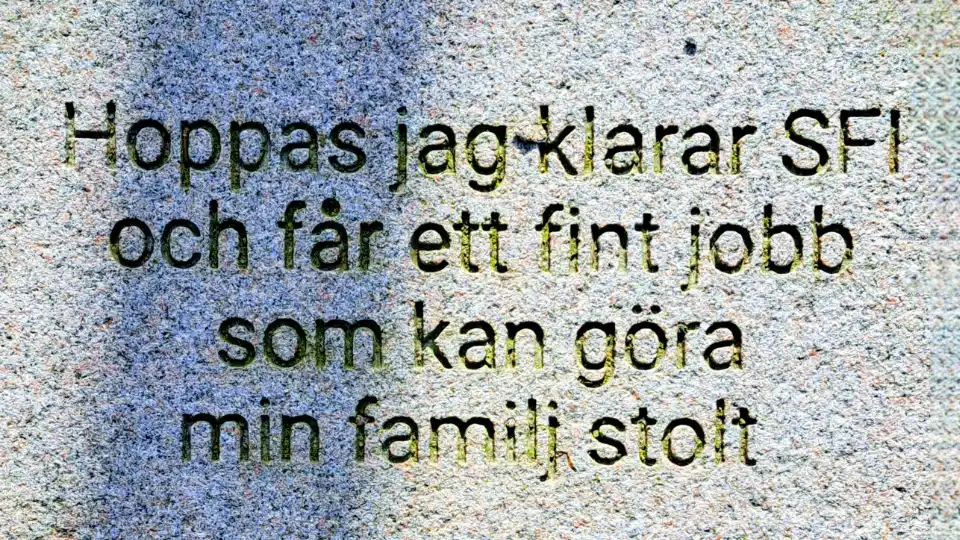 Närbild av en ljus, grov väggyta med blå skugga och svart text: ”Hoppas jag klarar SFI och får ett fint jobb som kan göra min familj stolt.”